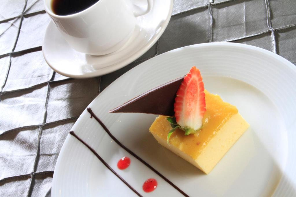 a piece of cake on a plate with a cup of coffee at Holiday Inn Monterrey-Parque Fundidora by IHG in Monterrey