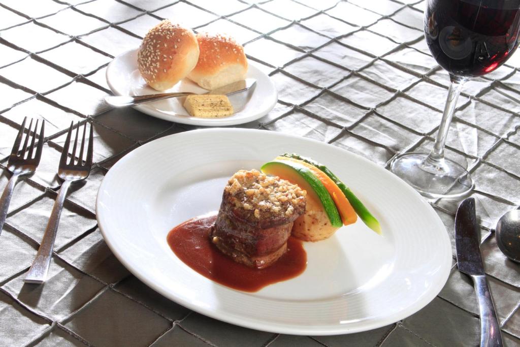 a table with two plates of food and a glass of wine at Holiday Inn Monterrey-Parque Fundidora by IHG in Monterrey