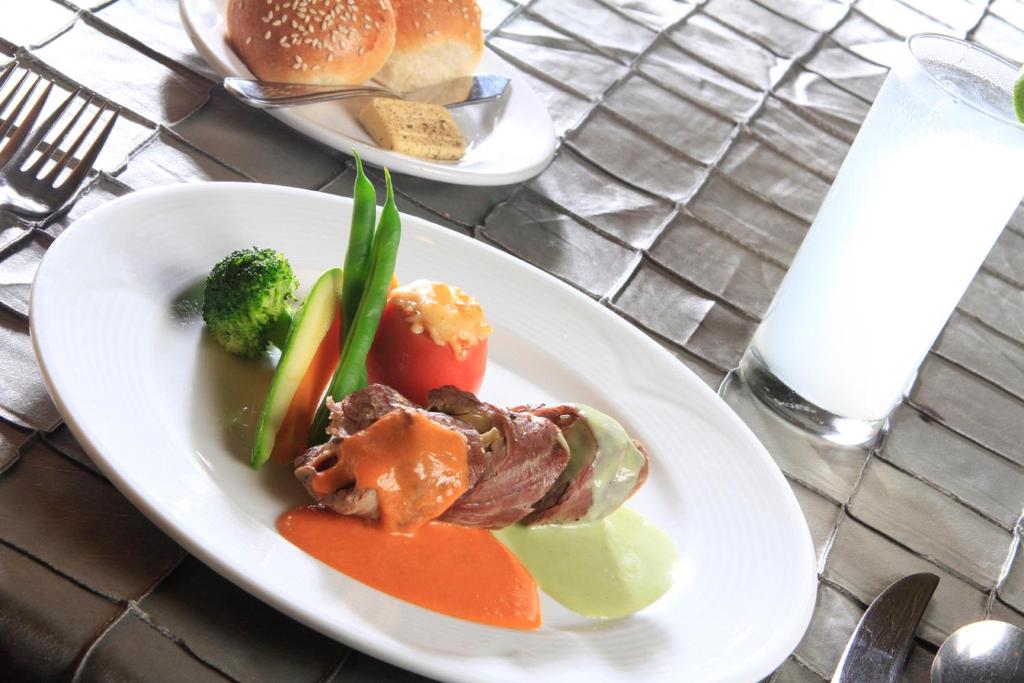 a plate of food with meat and vegetables on a table at Holiday Inn Monterrey-Parque Fundidora by IHG in Monterrey