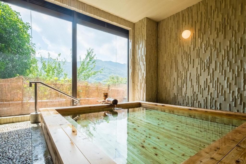 an indoor swimming pool with a large window at Apolosou in Yugawara