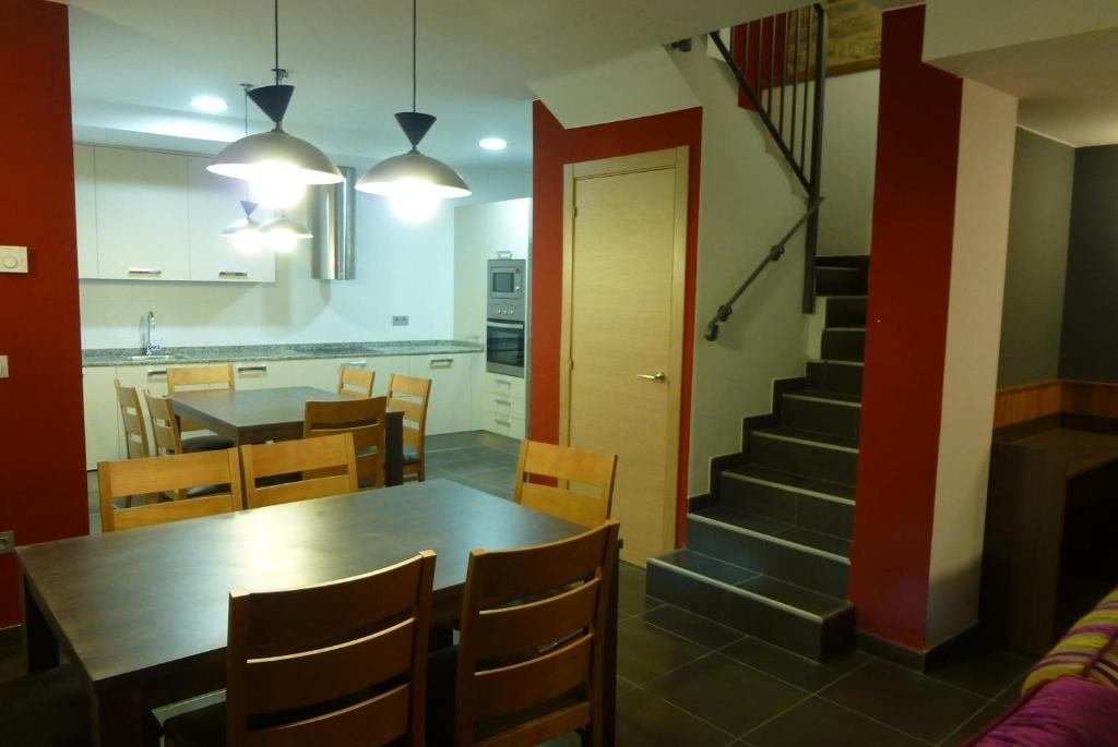 uma cozinha e sala de jantar com uma mesa e uma escada em La Solana de Jaca - Casa Collarada em Novés