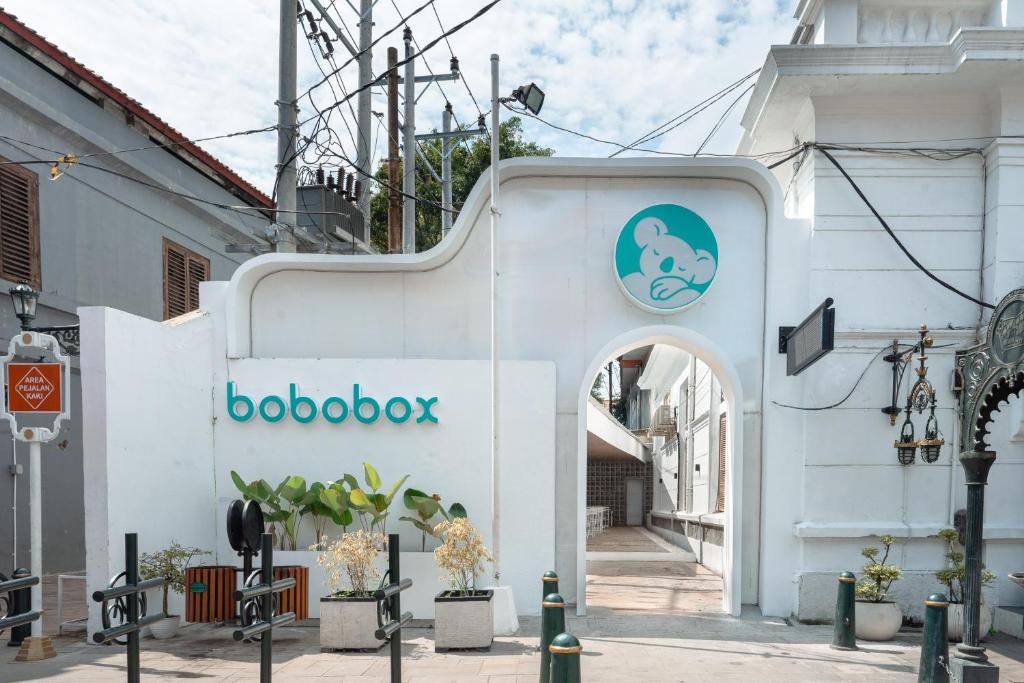 un bâtiment blanc avec un panneau qui lit le boobook dans l'établissement Bobopod Kota Lama, Semarang, à Semarang