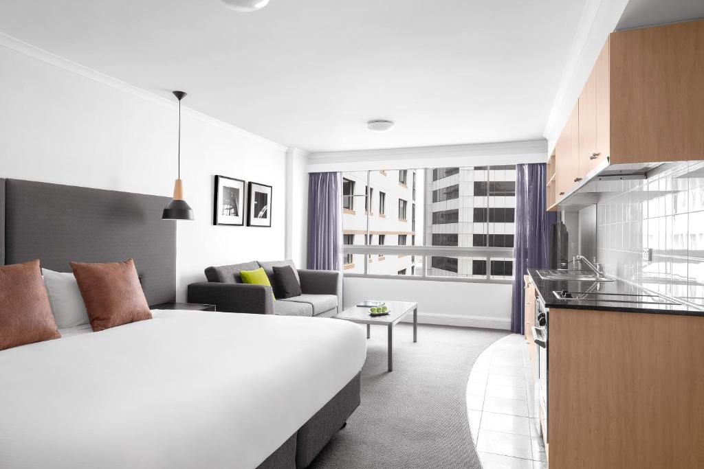 a hotel room with a large bed and a kitchen at Mantra on Kent in Sydney
