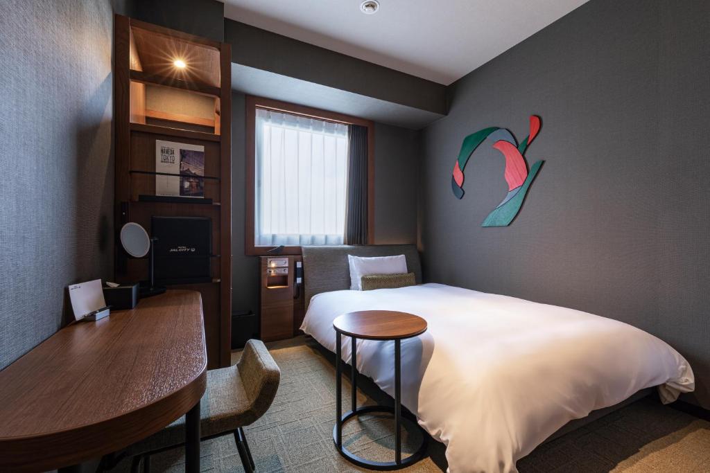 a bedroom with a bed and a table and a desk at Hotel JAL City Haneda Tokyo in Tokyo
