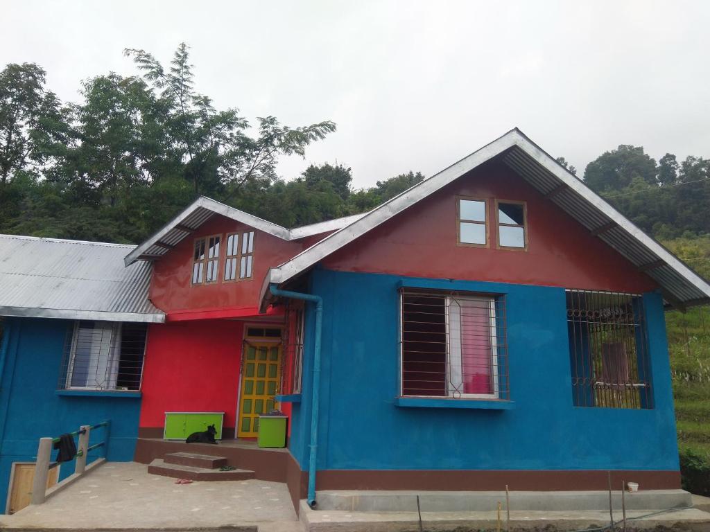 a blue and red house with a red at Pandeys Homestay Kalimpong in Kalimpong