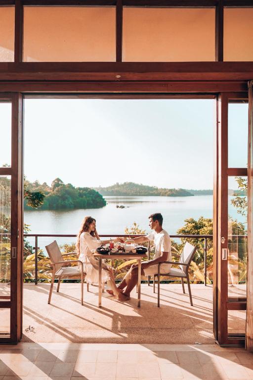 a man and woman sitting at a table on a balcony at Tri by Amaya in Ahangama