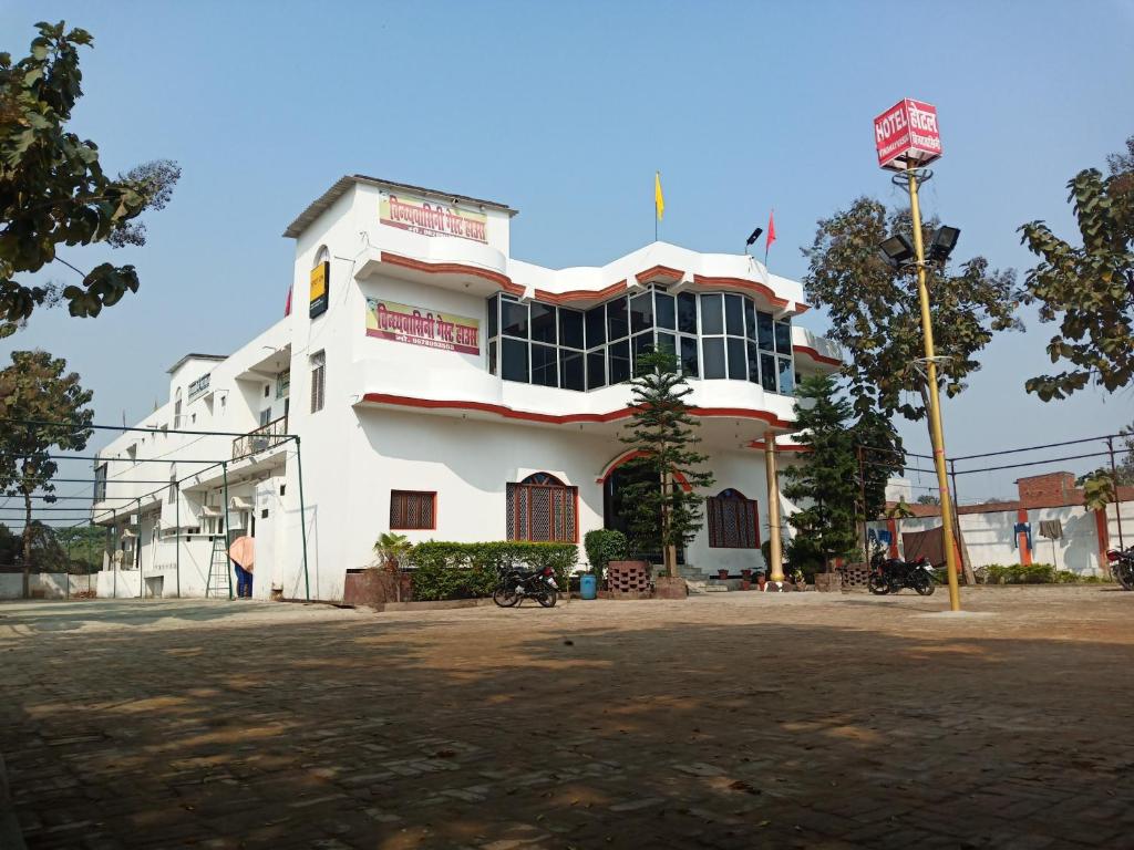 un edificio bianco con molte finestre di vindhyvasini guest house a Kushinagar