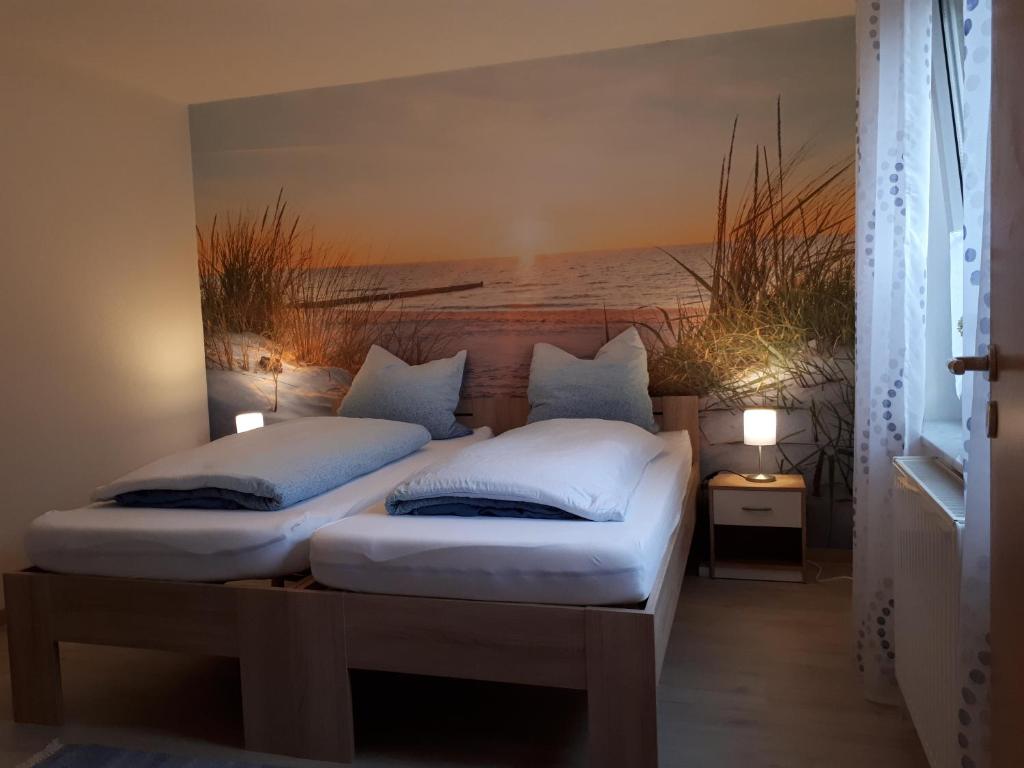 two twin beds in a room with a picture of the ocean at Gästewohnung Leinetal in Alfeld