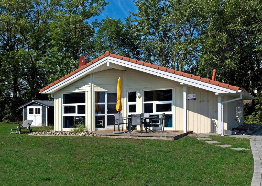 Cette petite maison dispose d'une terrasse couverte. dans l'établissement Dänische Ferienhäuser am Salzhaff Haus Im Wiesengrund, à Poel