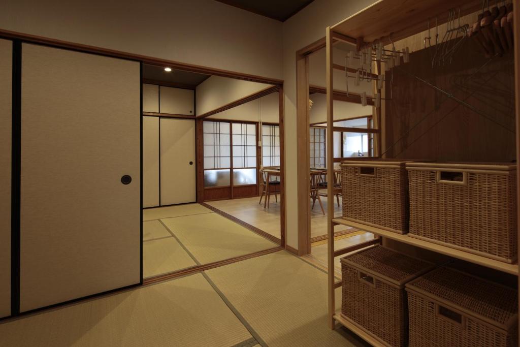 照宿 Terasu yado في Aira: غرفة مع باب يؤدي إلى غرفة طعام