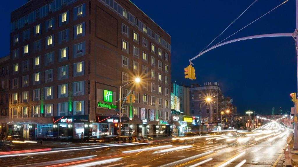 una calle de la ciudad por la noche con semáforos y edificios en Holiday Inn Lower East Side, an IHG Hotel en Nueva York