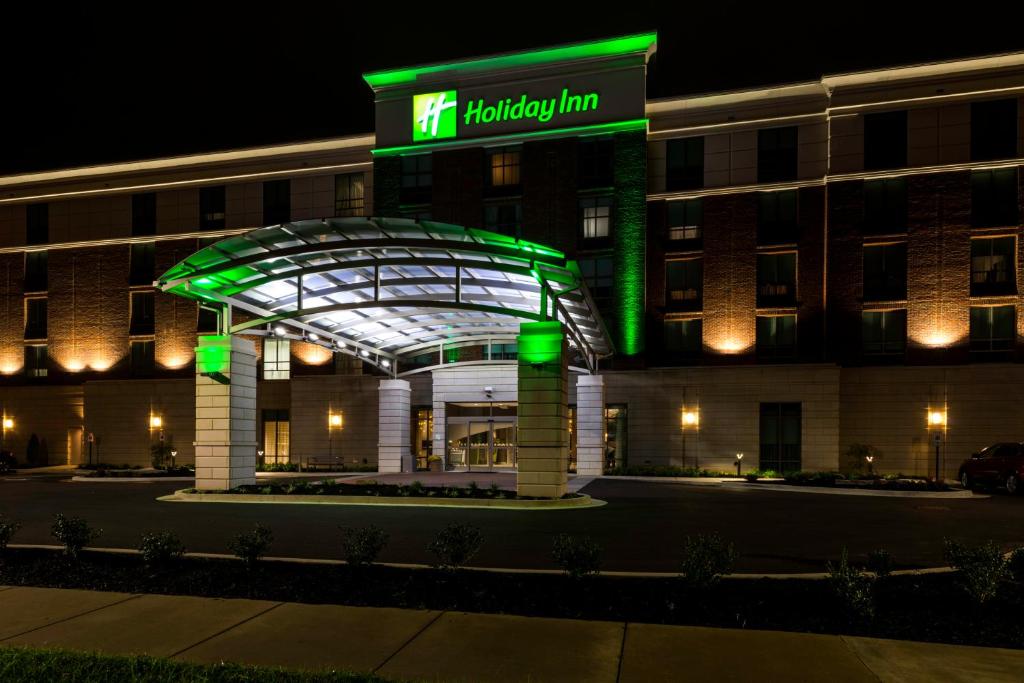 Holiday Inn Paducah Riverfront, an IHG Hotel في بادوكا: مبنى الفندق مع وجود لافتة لنزل عطلة