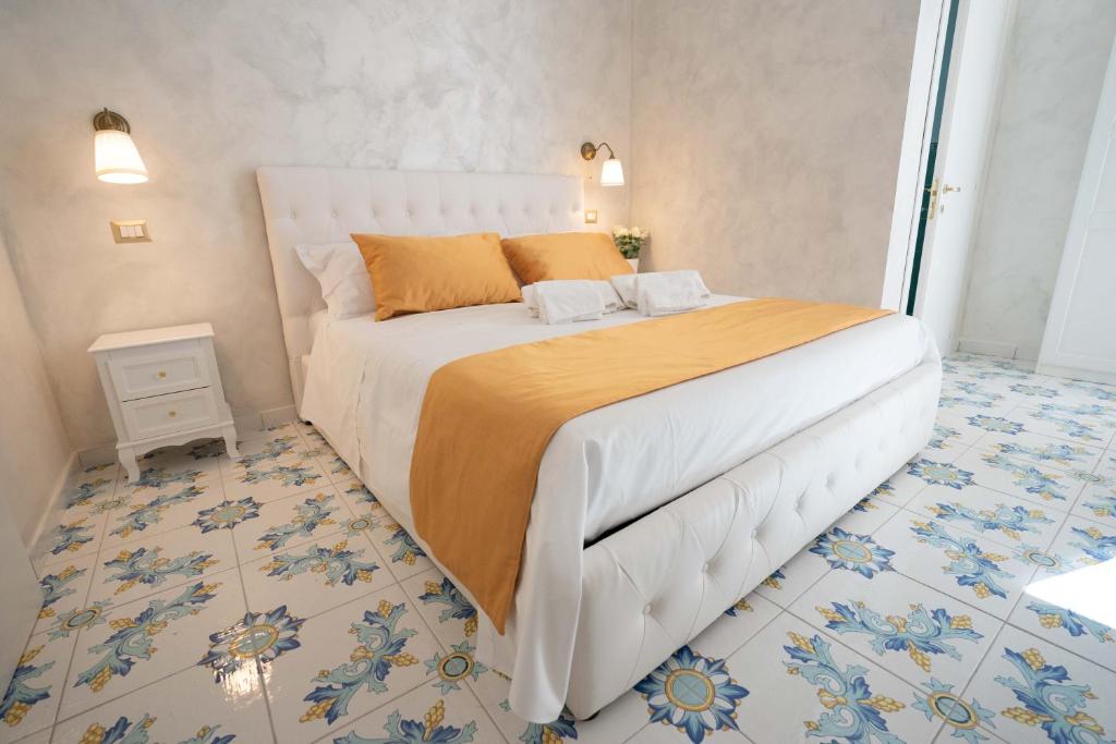 una camera da letto con un grande letto bianco con lenzuola arancioni di Alma Adry a Napoli