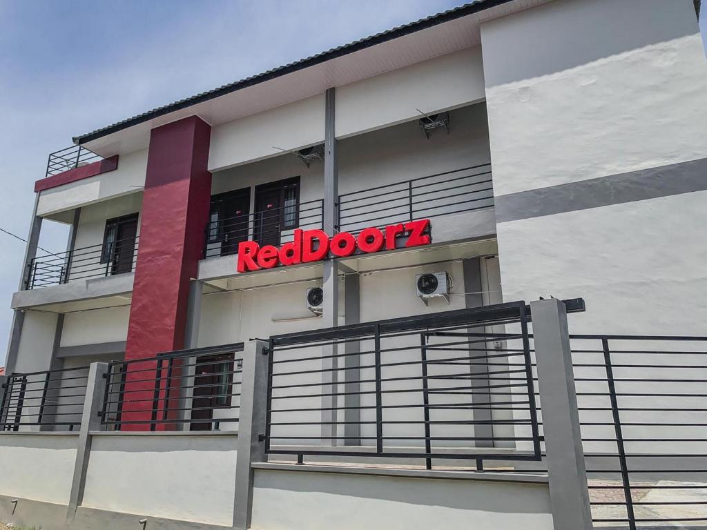una señal de puerta roja en el lateral de un edificio en RedDoorz Syariah near Universitas Syiah Kuala Aceh en Lamnyong