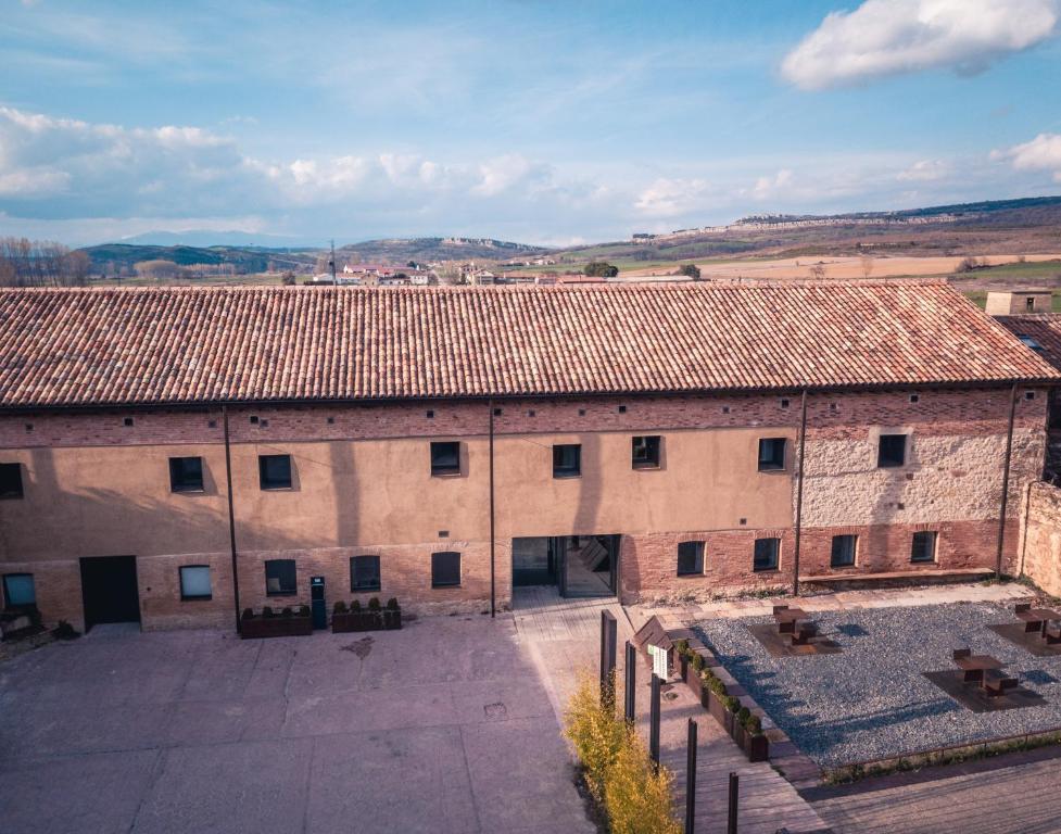 un gran edificio de ladrillo con un patio delante de él en Hotel y Estudios DCeres Estancias, en Santa María de Mave