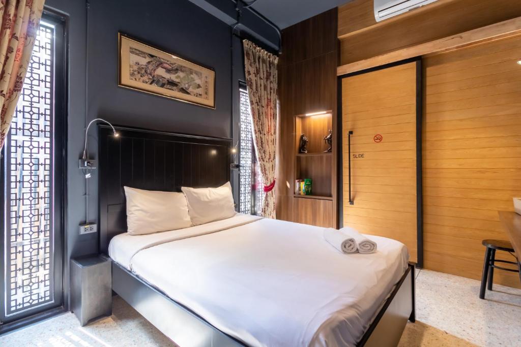 a bedroom with a large bed with white sheets at CLOUD on Saladaeng Silom Hostel Bangkok in Bangkok