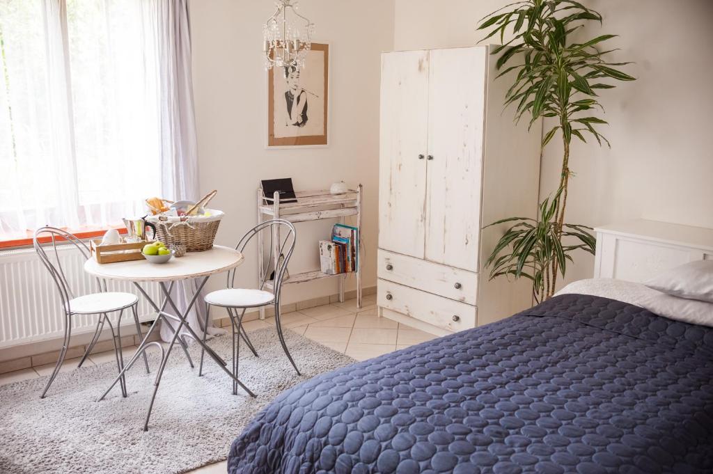 a bedroom with a bed and a table and chairs at Villa Letná in Brandýs nad Labem-Stará Boleslav