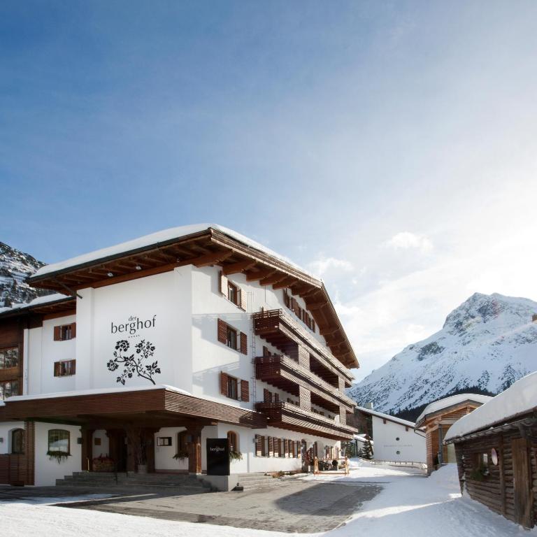 a hotel in the mountains with snow on the ground at Hotel Berghof in Lech am Arlberg