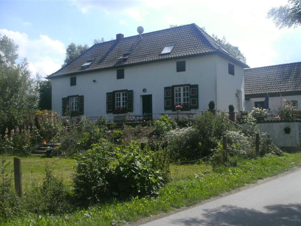 una casa blanca con techo negro en Ferienhaus Fristerhof, en Keeken