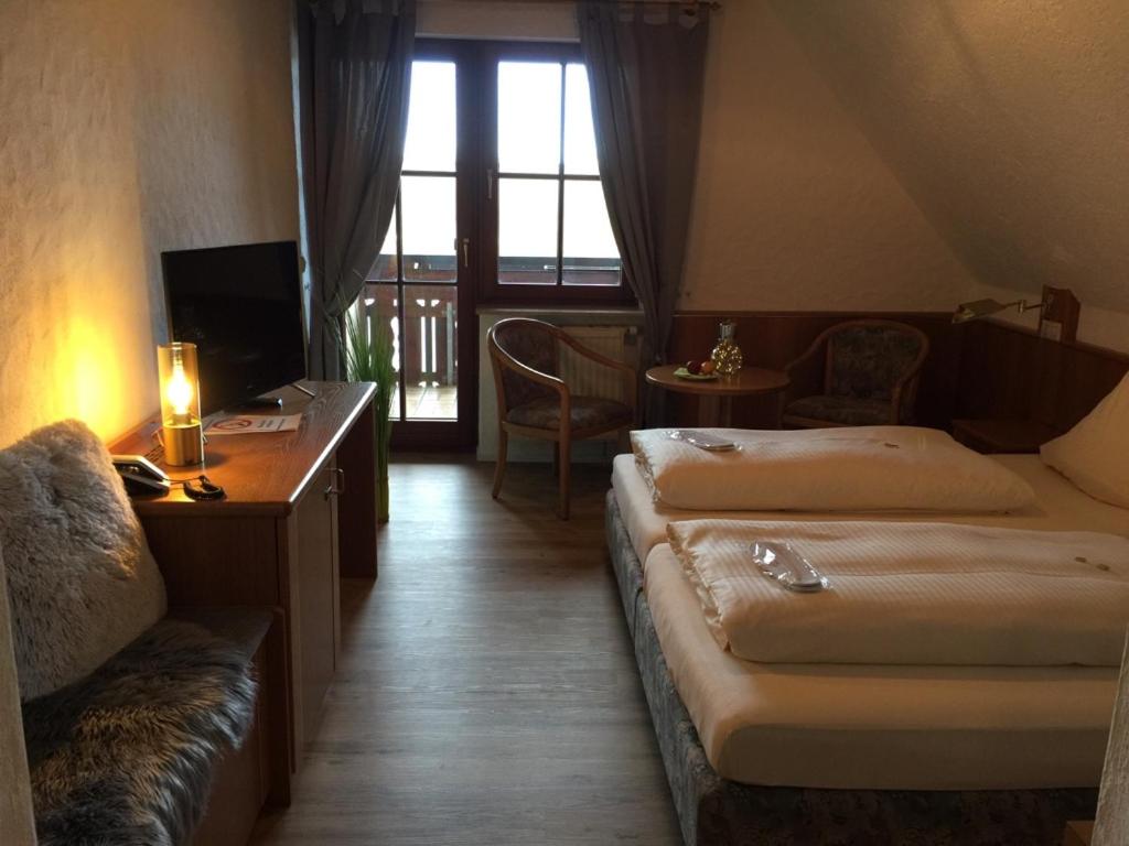 a hotel room with two beds and a television at See-Hotel Storchenmuehle in Fichtenau