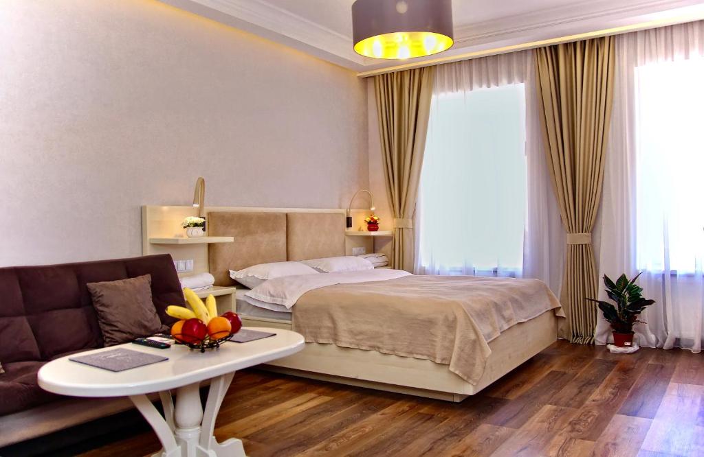 a bedroom with a bed and a table and a couch at Abano view apartment in Tbilisi City