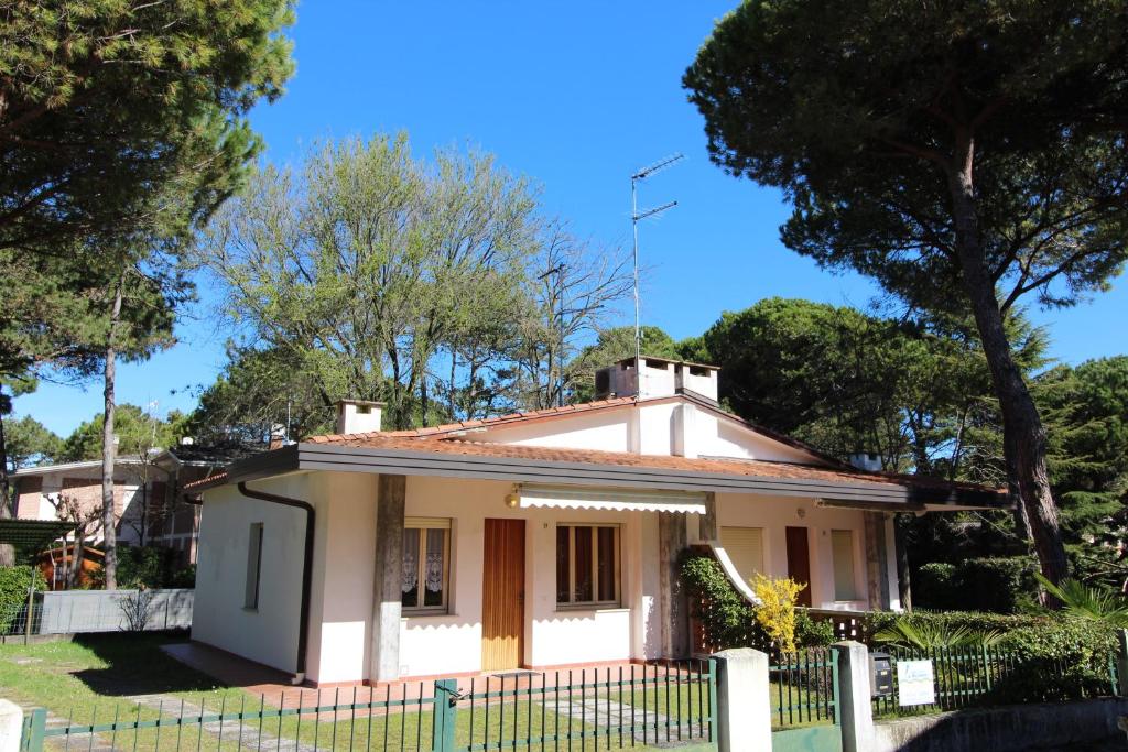 una piccola casa bianca con una recinzione di Villetta Sonia a Lignano Sabbiadoro