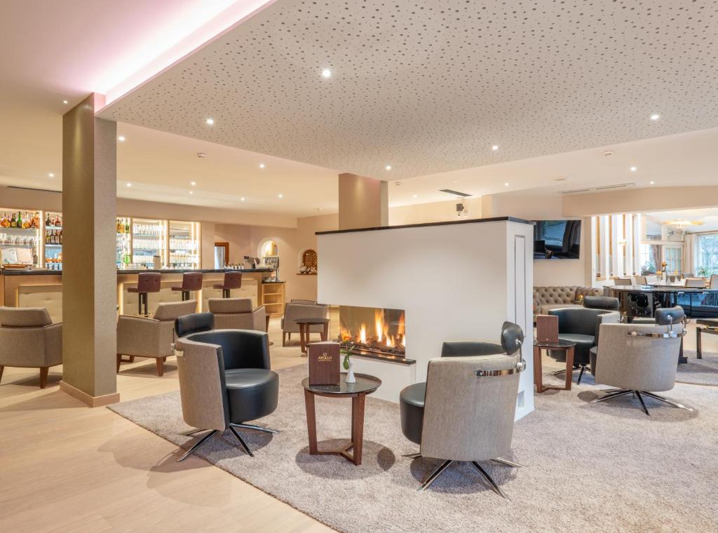 a waiting room with chairs and a fireplace at Thermenhotel Apollo in Bad Füssing