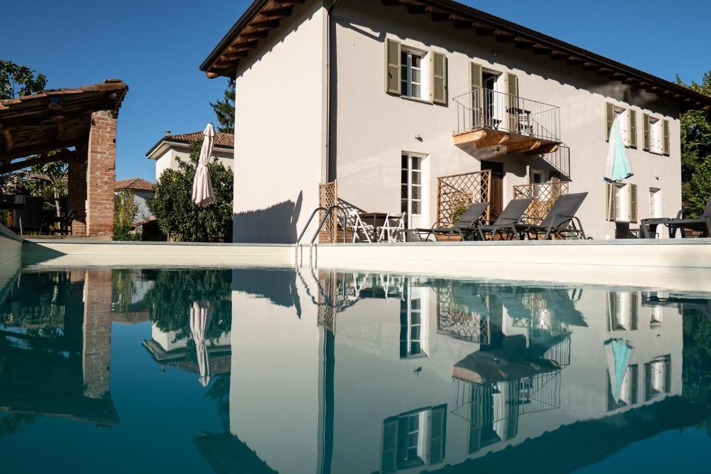 una casa e il suo riflesso in una piscina d'acqua di Cascina Allegria a Castelnuovo