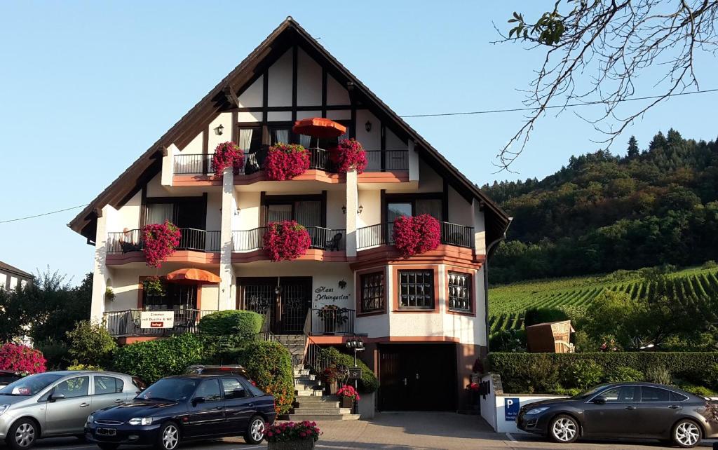 a building with cars parked in front of it at Haus Weingarten FERIENWOHNUNGEN in Ernst