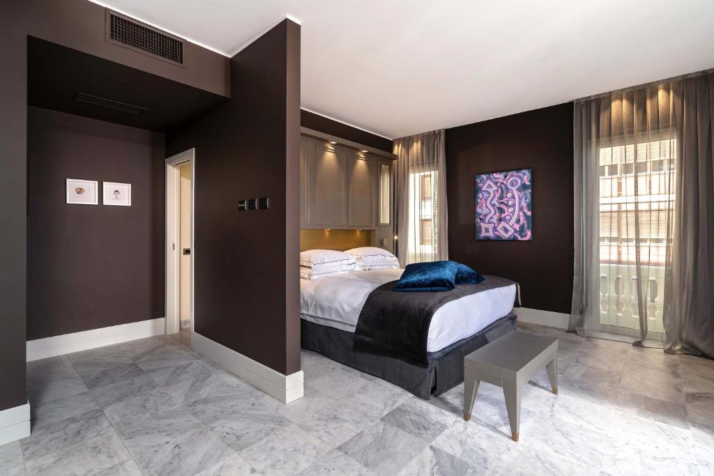 a bedroom with a large bed and a chair in it at Palazzo Doglio in Cagliari