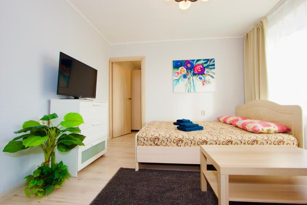 a bedroom with a bed and a table and a tv at Flatio on Old Arbat in Moscow