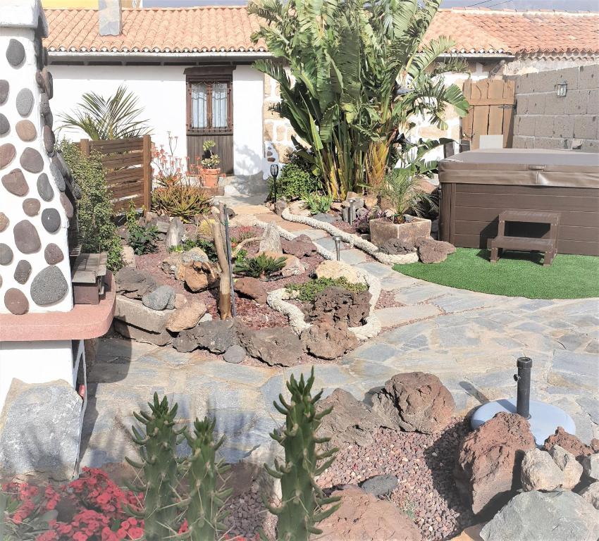 un jardín con rocas y plantas frente a una casa en Renllon en Lomo de Arico