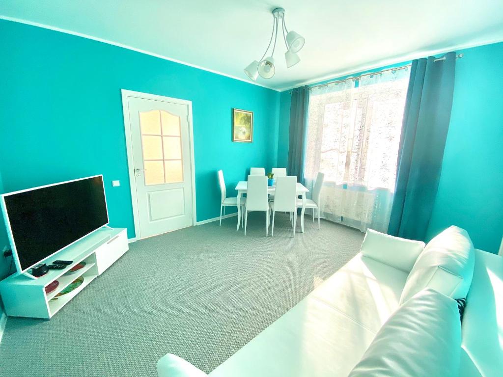 Sala de estar azul con sofá y TV en Love Apartment Riga, en Riga