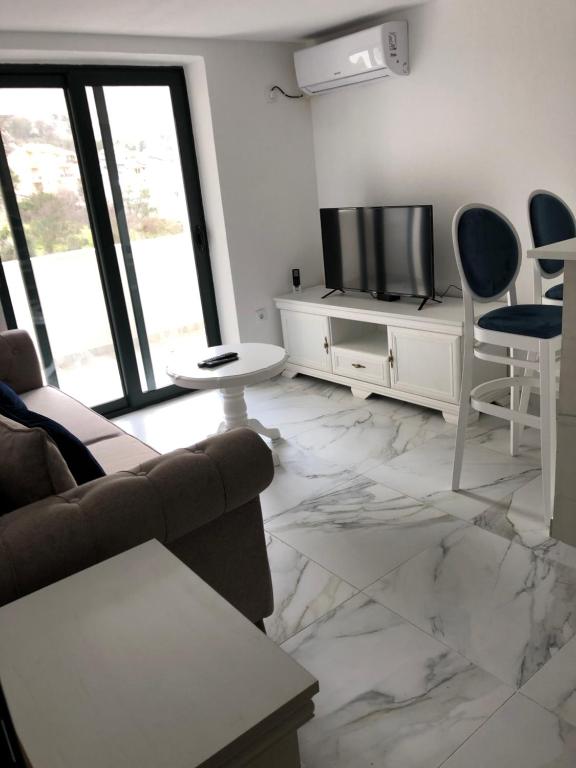 uma sala de estar com um sofá e uma televisão em Apartment Apollo 2 em Kotor