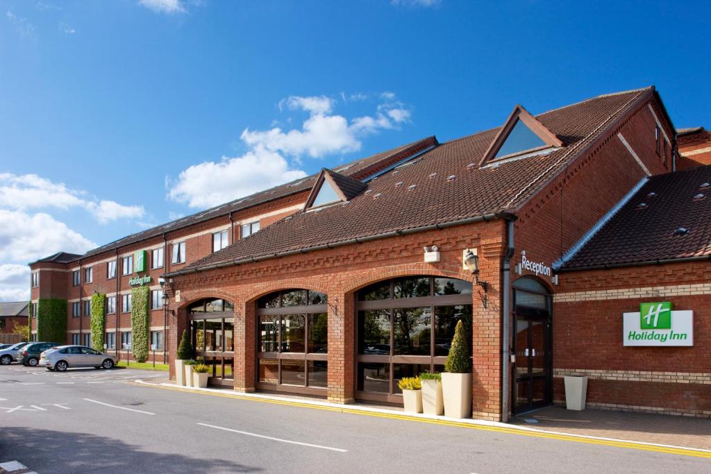 un gran edificio de ladrillo con una tienda delante en Holiday Inn Norwich North, an IHG Hotel, en Norwich
