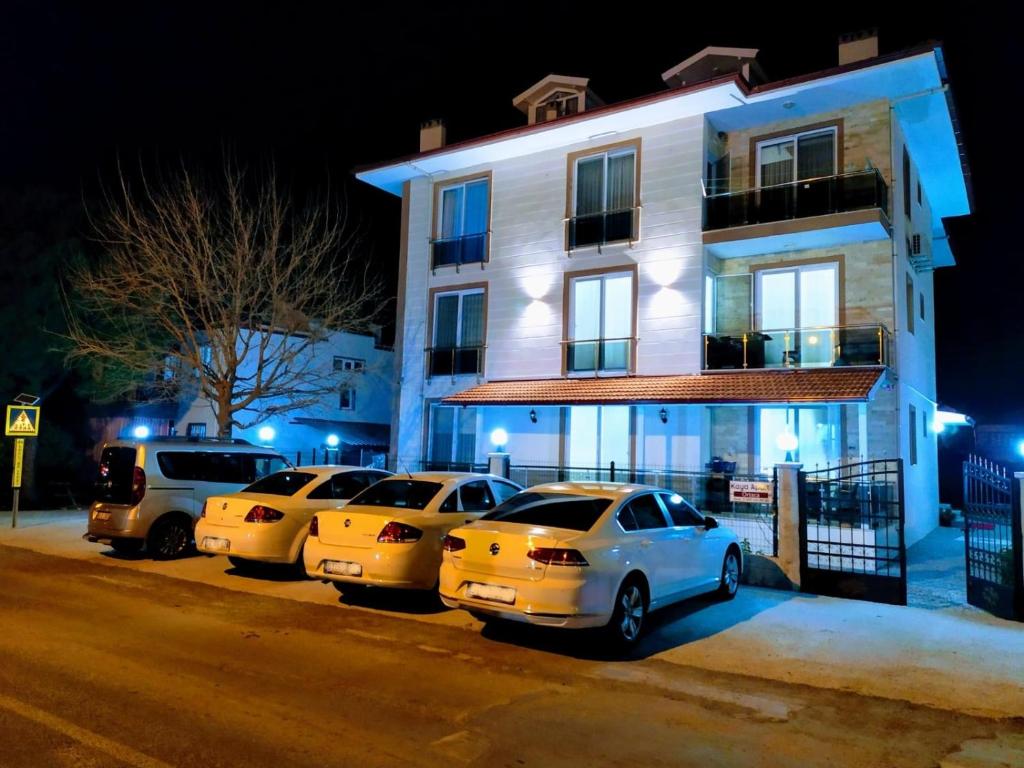 een groep auto's geparkeerd voor een gebouw bij Kaya Houses Günlük Daire in Ortaca