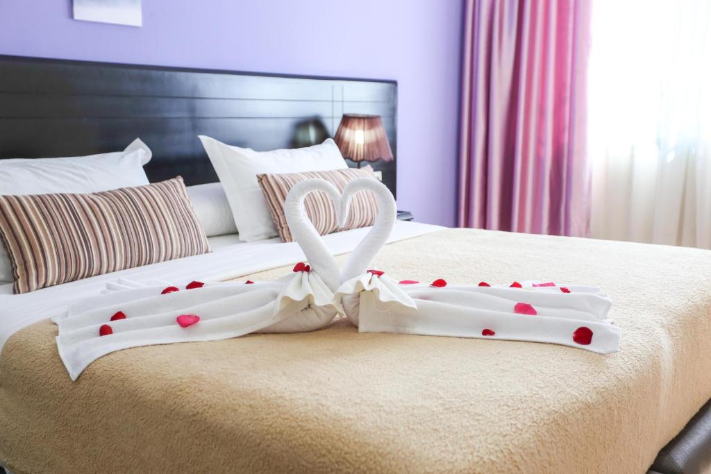 ein paar Handtücher auf einem Bett mit Herzen in der Unterkunft Hôtel Suite Martil in Martil