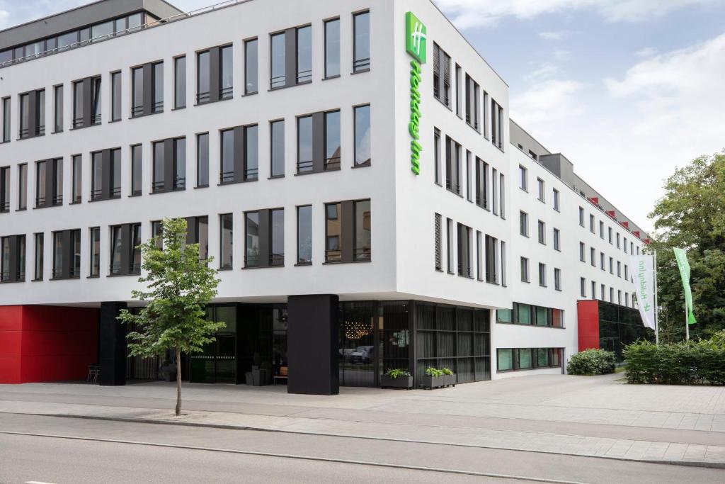 um edifício de escritórios com um sinal verde em Holiday Inn Munich - Westpark, an IHG Hotel em Munique