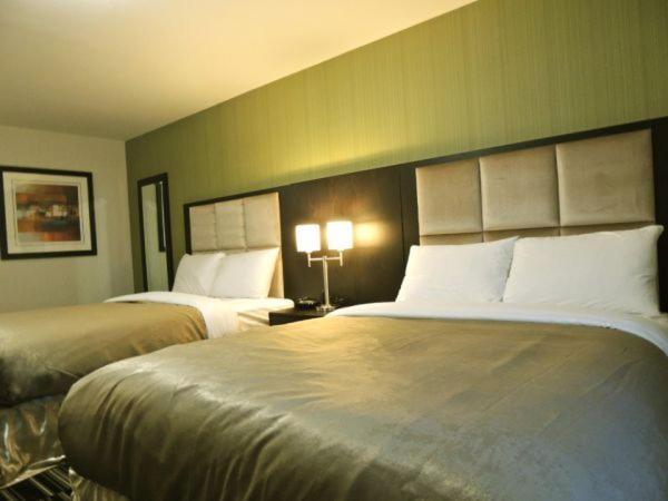 a hotel room with two beds and two lamps at Western Star Inn and Suites Carlyle in Carlyle