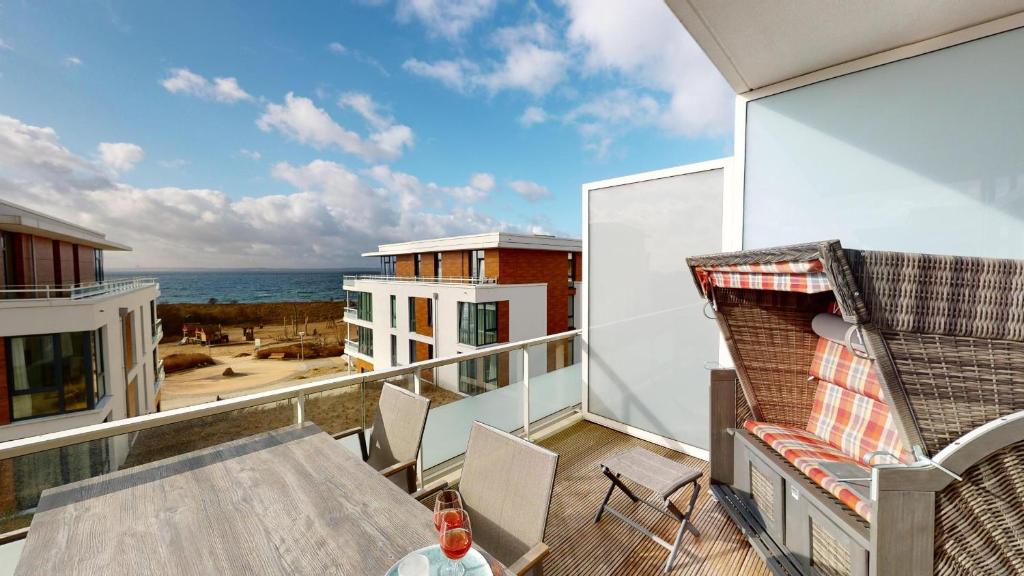 einen Balkon mit einem Tisch und Meerblick in der Unterkunft Südkap B-09 in Pelzerhaken