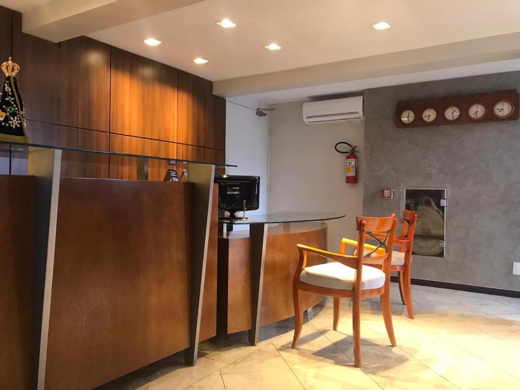 uma cozinha com duas cadeiras, uma mesa e um balcão em Nena Suite Hotel em Franca