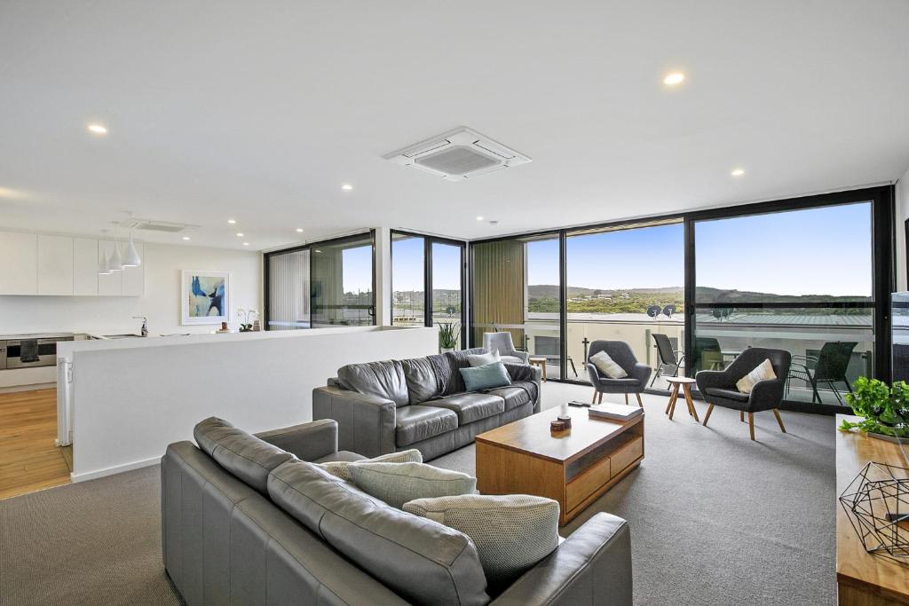 a living room with couches and chairs and a counter at Stunning Main Beach Location- Anglesea in Anglesea
