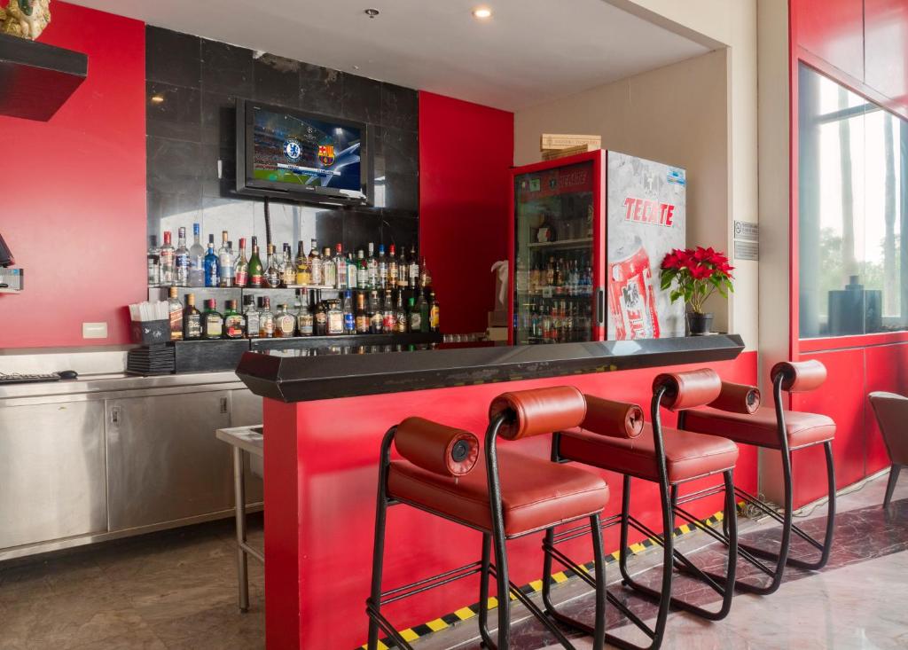 a red bar with stools in front of it at Holiday Inn Monterrey-Parque Fundidora by IHG in Monterrey