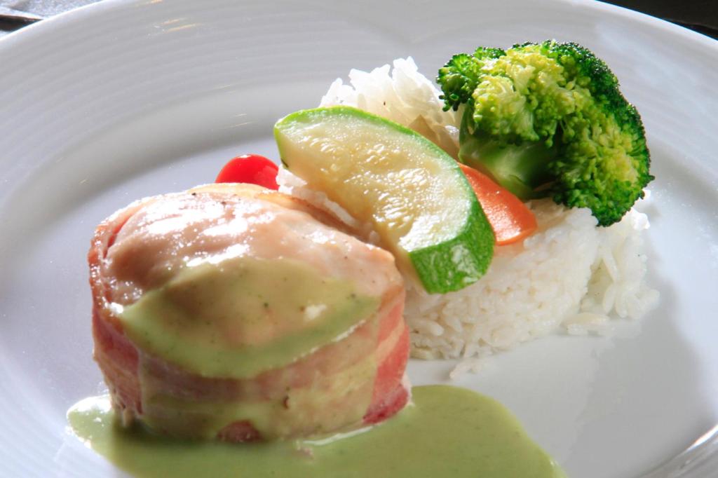 a white plate of food with rice and broccoli at Holiday Inn Monterrey-Parque Fundidora by IHG in Monterrey