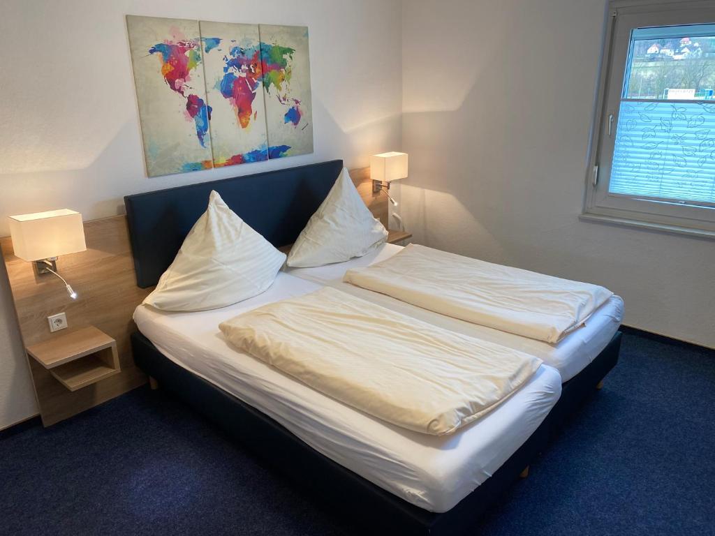 a bed in a room with two pillows on it at Motel Herbold in Knüllwald