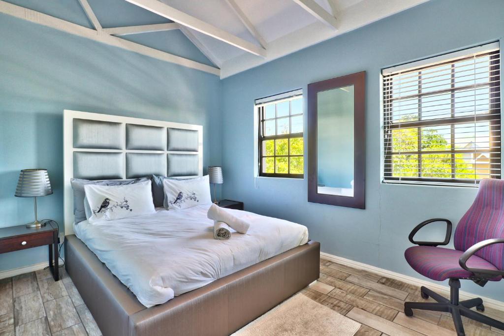 1 dormitorio con cama y silla morada en Milton mews, en Ciudad del Cabo