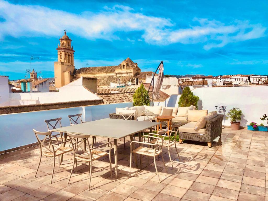 um pátio com uma mesa e cadeiras no telhado em Casa Turística San Agustín em Córdoba