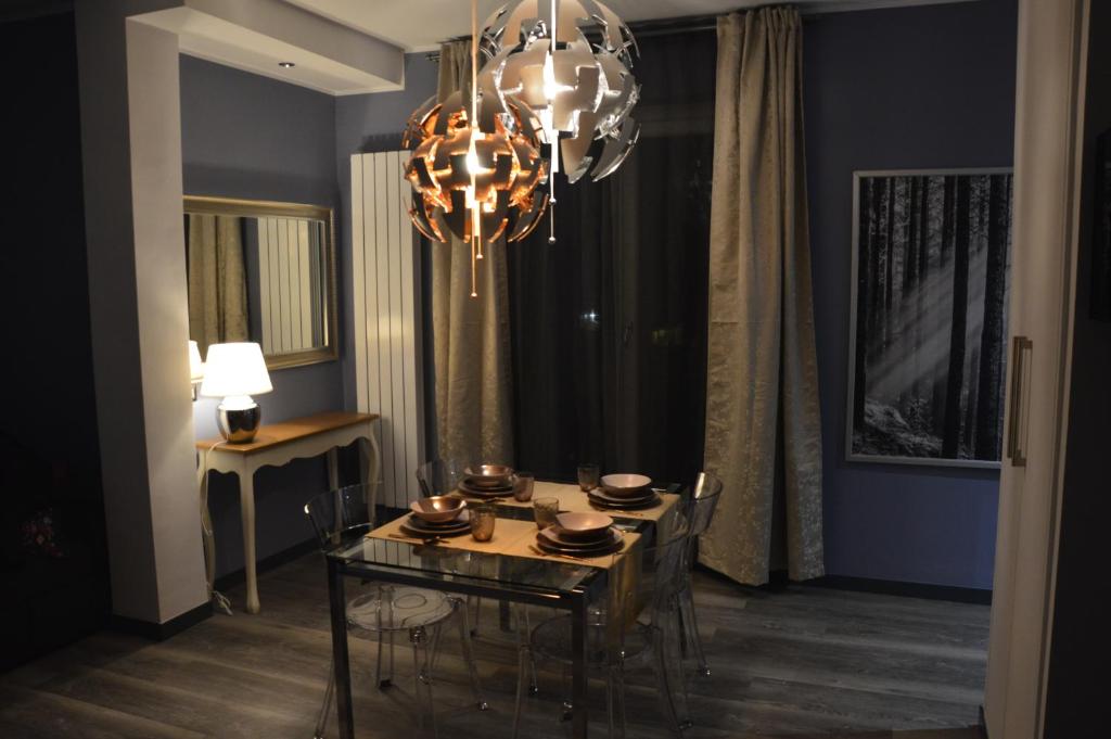 ein Esszimmer mit einem Tisch und einem Kronleuchter in der Unterkunft Luxury Bellevue Centro Città in Pescara