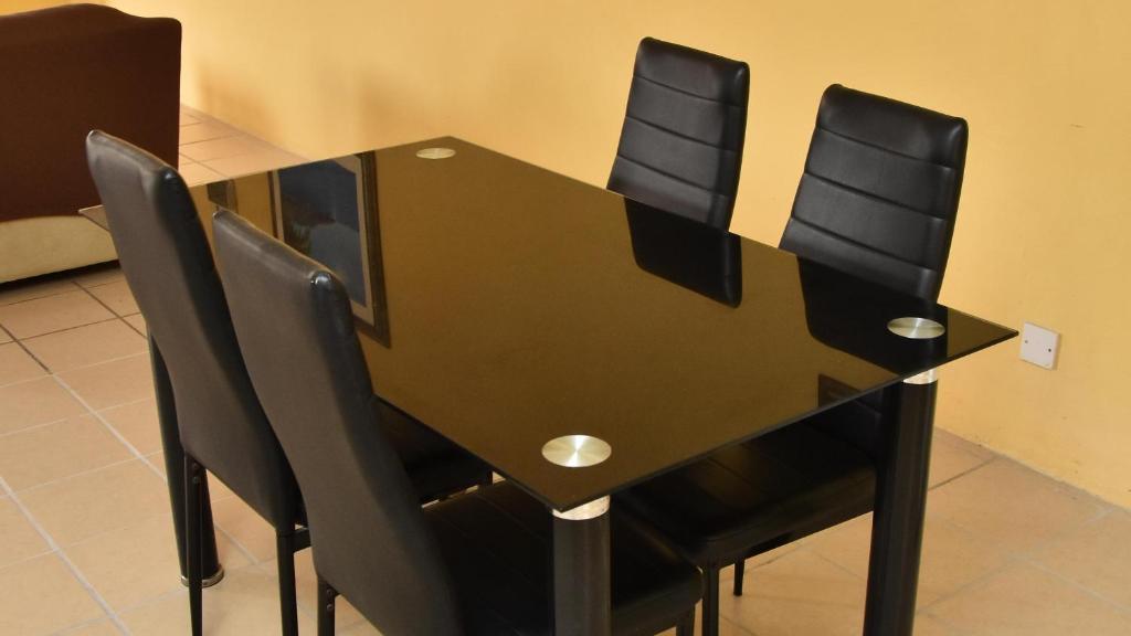 - une table à manger noire avec 4 chaises noires dans l'établissement Aanola Villas A5 Hushed Hacienda, à Charlotte