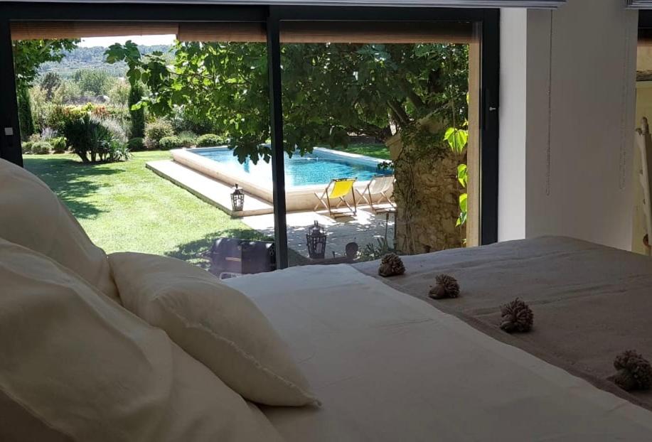 1 cama en un dormitorio con vistas a la piscina en La Melizanne, en Fuveau